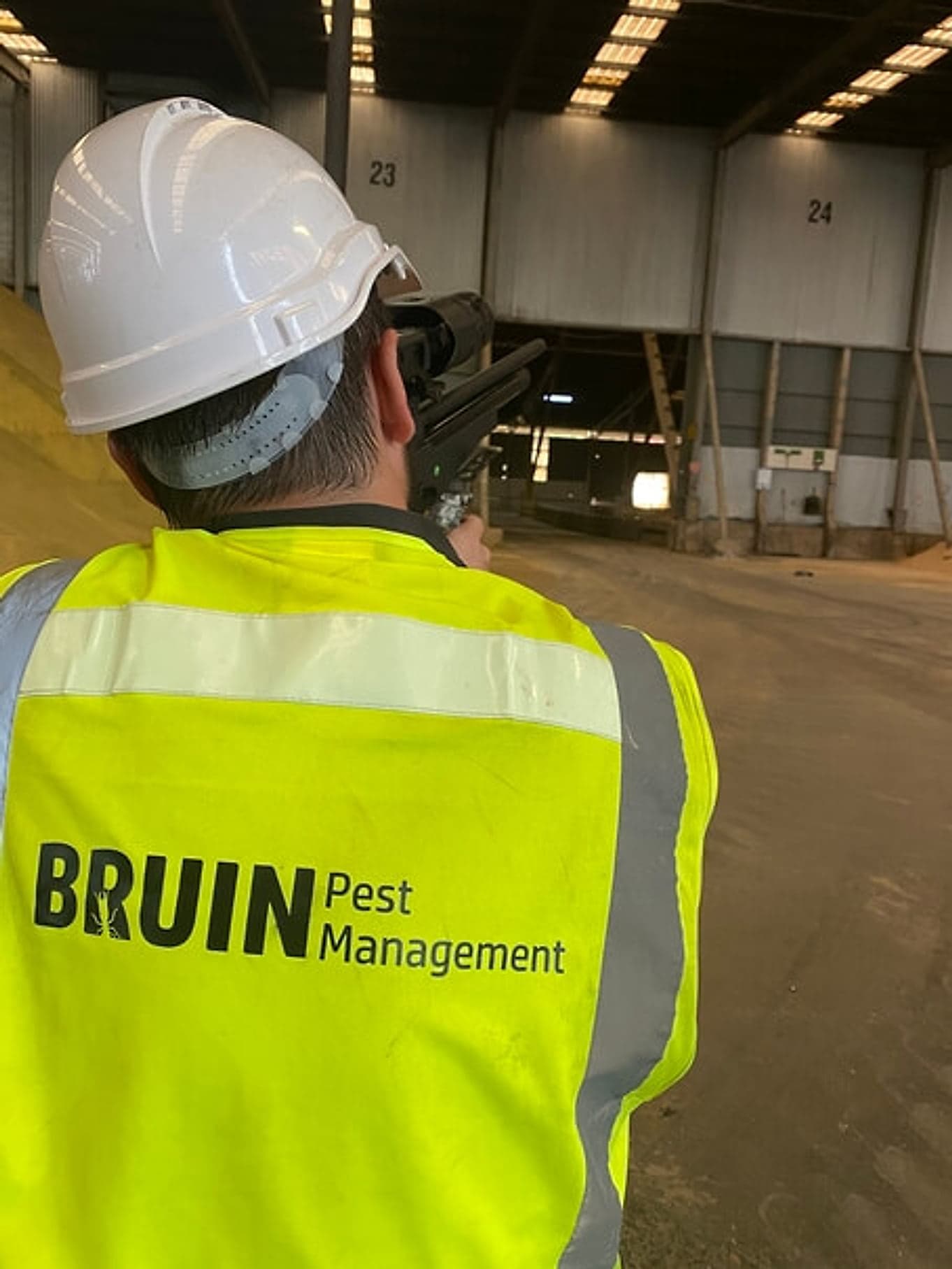 Bruin technician in hi-vis inspecting a commercial premises for pests